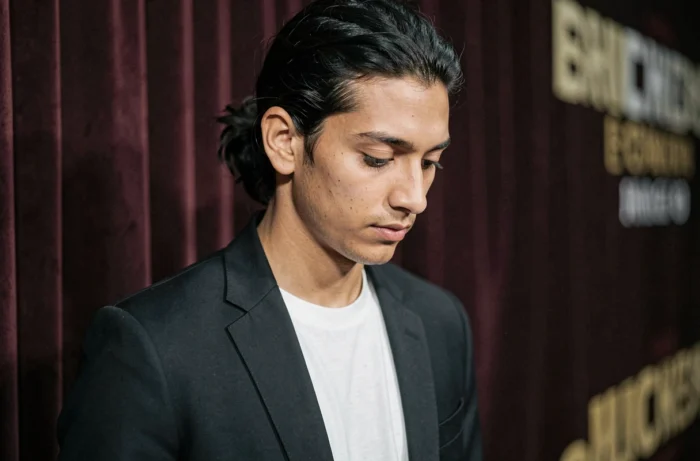 Jeune homme en blazer noir photographié en coulisses lors d'un événement culturel, portrait éditorial illustrant la personnalité discrète et artistique de Jack John Christopher Depp III